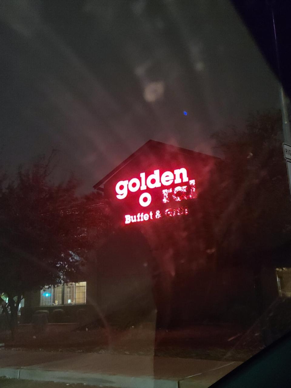 Neon sign of 'Golden Corral Buffet & Grill' reads "golden oral"