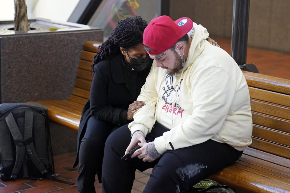 CORRECTS FIRST NAME TO DAMIK INSTEAD OF DARNIK - A unidentified member of the clergy, left, prays with Damik Wright, the brother of Daunte Wright, Tuesday, Nov. 30, 2021, at the Hennepin County Government Center in Minneapolis prior to the start of jury selection for former suburban Minneapolis police Officer Kim Potter, who says she meant to grab her Taser instead of her handgun when she shot and killed motorist Daunte Wright. (AP Photo/Jim Mone)