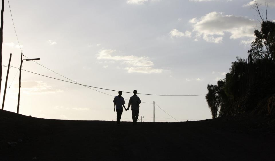 Two people shown as silhouettes are holding hands