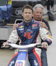 FILE - Mario Andretti rides with his grandson, driver Marco Andretti, to the pits before practice for the IndyCar auto race on Belle Isle in Detroit, in this Friday, June 1, 2012, file photo. Marco Andretti made the decision at the start of this year to step away from full-time racing and essentially end three generations of the most famous family in motorsports competing at the highest level. (AP Photo/Carlos Osorio, File)