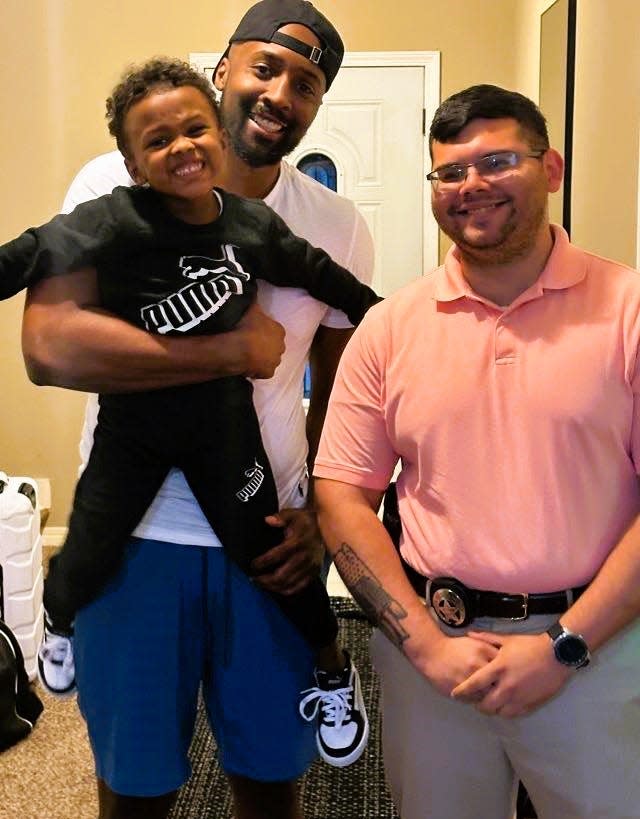 Dr. Jamaan Kenner of Wichita Falls holds his son, Jrue Kenner, Thursday, Oct. 12, 2023, after law enforcement officers found the 3-year-old safe in Louisiana. The New Orleans police detective pictured on the right was on the case.