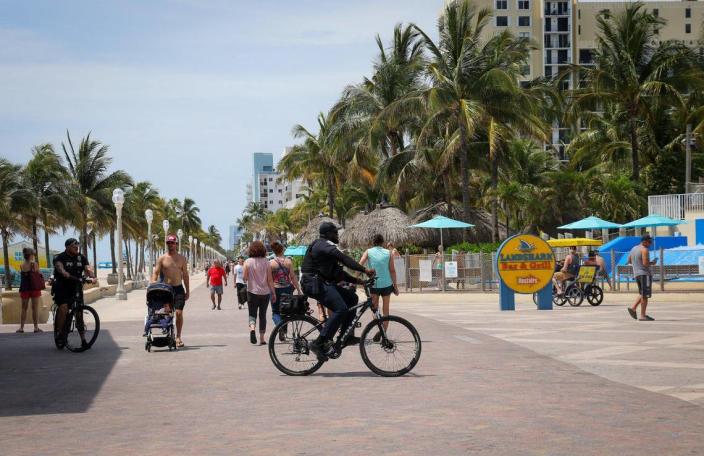 On Tuesday, May 30, 2023 police officers, tourists and locals mingle on the Hollywood Beach Broadwalk the day after a mass shooting left nine people injured. A witness recounts his efforts to help wounded people. --