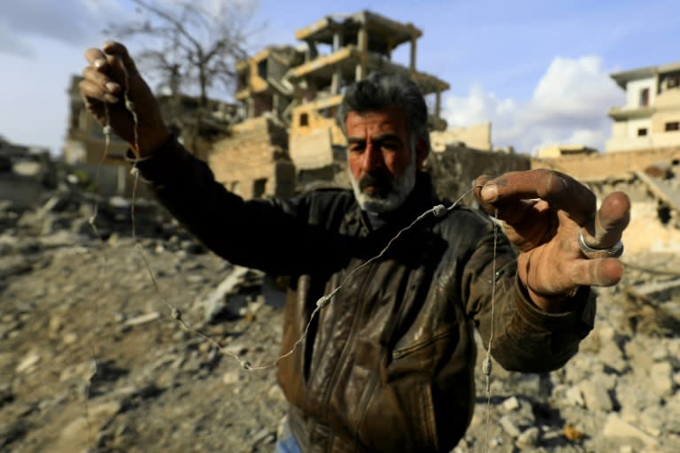 Abu Mohammed holds a wire from a mine left by the Islamic State (IS) group in the Syrian city of Raqa