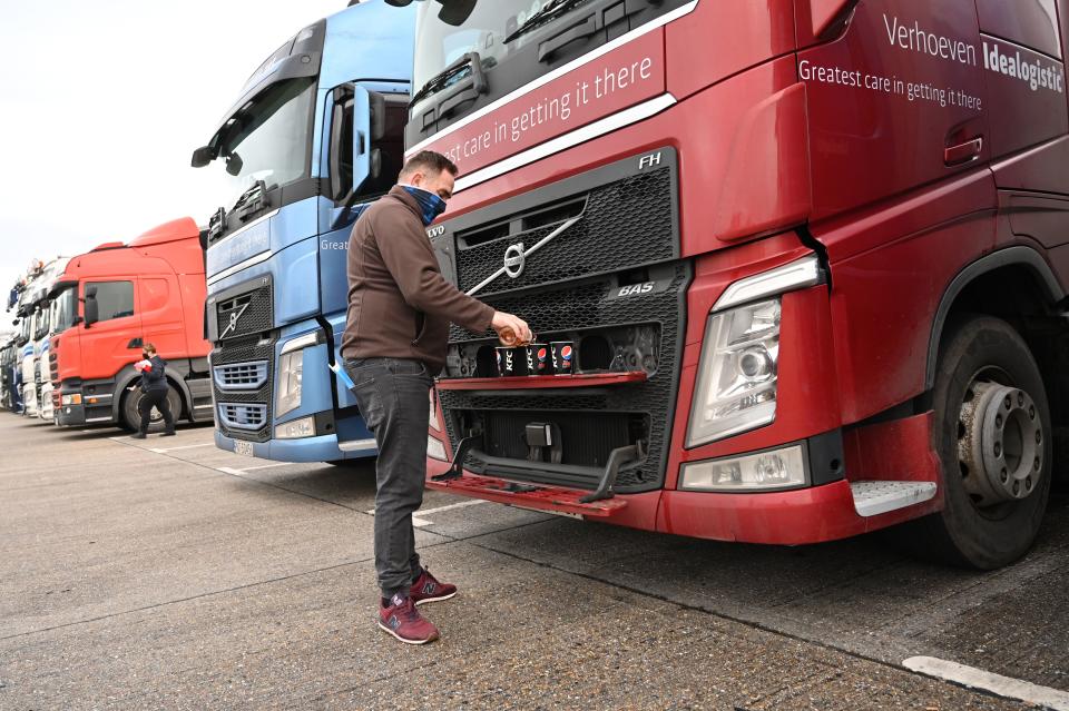 A Polish driver pours drinks for him and his colleagues as they wait at a truck stop off the M20 leading to Dover near Folkestone in Kent, south east England on December 22, 2020, after France closed its borders to accompanied freight arriving from the UK due to the rapid spread of a new coronavirus strain. - Britain sought to sound a note of calm saying they were working as fast as possible to unblock trade across the Channel after France shut its borders to UK hauliers in a bid to contain a new variant of the coronavirus. (Photo by JUSTIN TALLIS / AFP) (Photo by JUSTIN TALLIS/AFP via Getty Images)