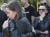 People hug each other as they commemorate the victims of the attack on a vocational college, in Kerch, Crimea, Thursday, Oct. 18, 2018. Authorities on the Crimean Peninsula were searching for a possible accomplice of the student who carried out a shooting and bomb attack on a vocational school Wednesday, killing 20 people and wounding more than 50 others, an official said Thursday. (AP Photo)