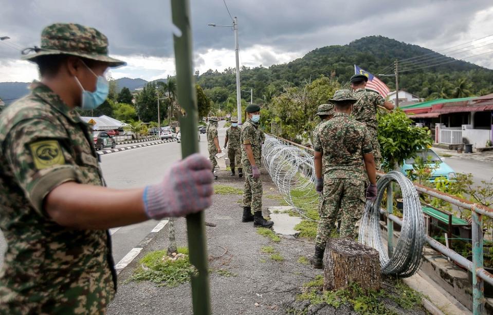 Armed Forces personnel are seen putting up barbed wires at Zon B and Zon C of Taman Meru 2C in Ipoh that will be put under the enhanced movement control order (EMCO) for two weeks. ― Picture by Farhan Najib