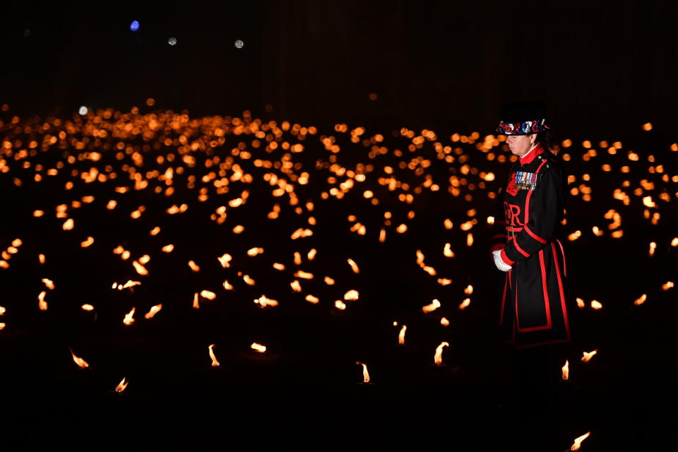 <p>A Yeoman Warder, commonly referred to as a ‘Beefeater’, stands amongst the first of thousands of lit flames which form part of an installation called ‘Beyond the Deepening Shadow: The Tower Remembers’, in the dry moat of the Tower of London, to mark the centenary of the end of World War One, Sunday Nov. 4, 2018. (Photo from John Stillwell/PA via AP) </p>