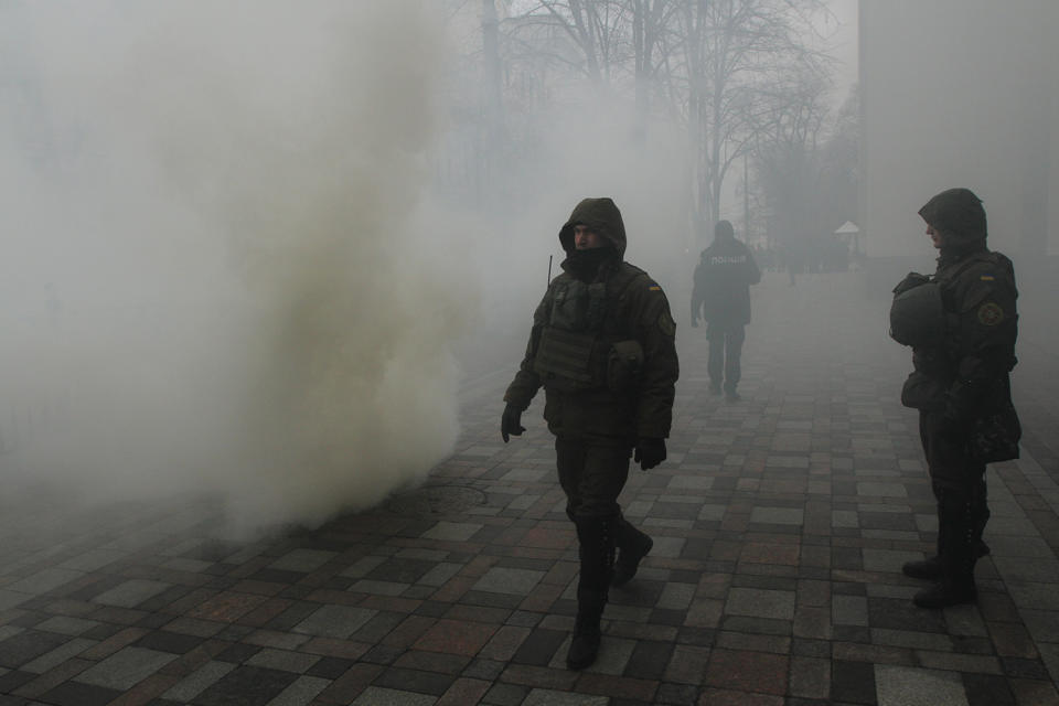 <p>Policemen are seen guarding in a smoke during a protest at a parliament building in Kyiv. Three ukrainian far right organizations Azov, Svoboda and Right Sector gather about 10 thousands of its members and supporters for a “March of National Dignity” downtown Kiev, Ukraine Feb. 22, 2017. (Sergii Kharchenko/NurPhoto via Getty Images) </p>