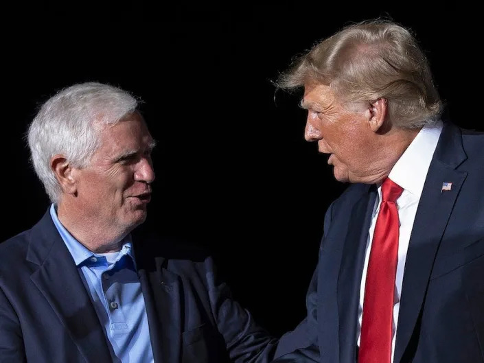 Republican Rep. Mo Brooks of Alabama shakes hands with then-President Donald Trump on stage at a political rally in Cullman, Alabama in August 2021.