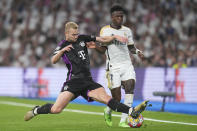 Real Madrid's Vinicius Junior, right, is challenged by Bayern's Matthijs de Ligt during the Champions League semifinal second leg soccer match between Real Madrid and Bayern Munich at the Santiago Bernabeu stadium in Madrid, Spain, Wednesday, May 8, 2024. (AP Photo/Manu Fernandez)