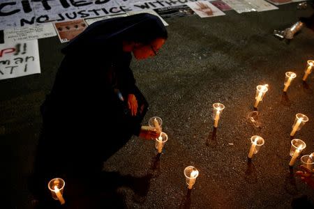 A nun holds a candle during a demonstration against Indonesia's decision to execute 14 drug convicts in front of the Presidential Palace in Jakarta, Indonesia, July 28, 2016. REUTERS/Beawiharta