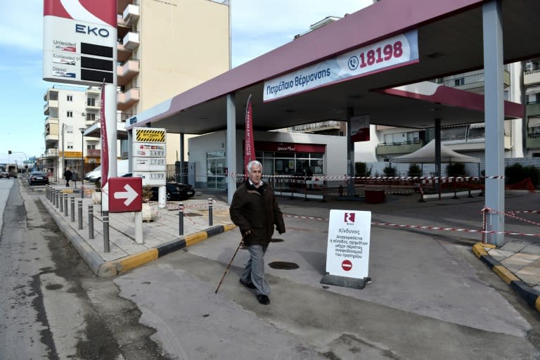 A man walks next to a petrol station in Thessaloniki, northern Greece where a World War II unexploded bomb was found during work to expand a petrol station's underground tanks on February 8, 2017