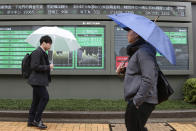 People walk past an electronic stock board of a securities firm in Tokyo, Wednesday, Jan. 8, 2020. Oil prices rose and Asian stock markets fell Wednesday after Iran fired missiles at U.S. bases in Iraq in retaliation for the killing of an Iranian general. Tokyo's stock market benchmark fell nearly 2%. (AP Photo/Koji Sasahara)