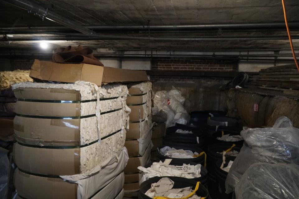 Stacks of rags, mostly discarded cotton, sit in the back of the basement, ready to be made into paper. 