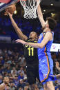 Utah Jazz guard Kris Dunn, left, shoots over Oklahoma City Thunder forward Chet Holmgren, right, in the second half of an NBA basketball game, Wednesday, March 20, 2024, in Oklahoma City. (AP Photo/Kyle Phillips)
