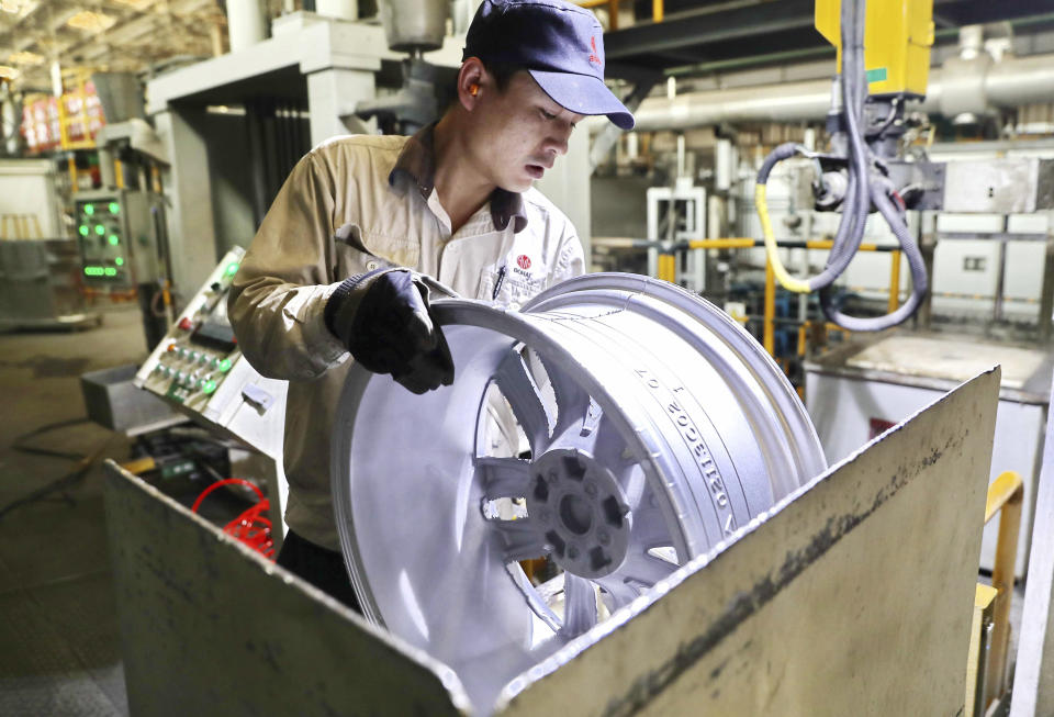 In this Monday, Feb. 11, 2019, photo, a laborer works on an aluminum wheel hub at a manufacturing facility in Qinhuangdao in northern China's Hebei province. U.S. and Chinese negotiators meet this week for their final trade talks before President Donald Trump decides whether to go ahead with a March 2 tariff hike on $200 billion of imports from China. (Chinatopix via AP)