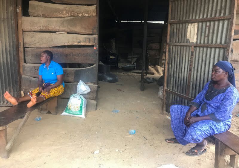 Women sit in front of a rice mill in Wurukum area of Makurdi town