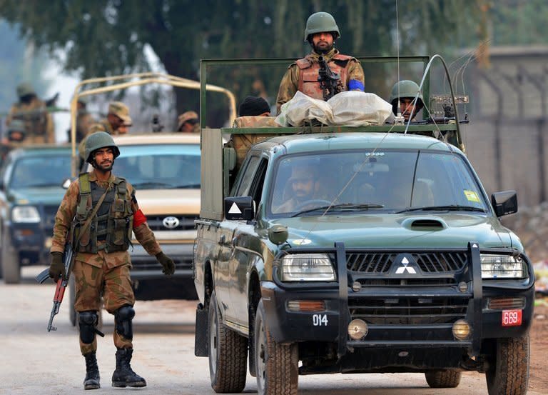 Army personnel gather outside Peshawar airport in Peshawar, northwest Pakistan, on December 16, 2012 after it was attacked by militants late Saturday. Six people were killed Sunday as police and troops battled militants armed with automatic weapons, grenades and mortars in Peshawar, a day after a deadly Taliban raid on the city's airport