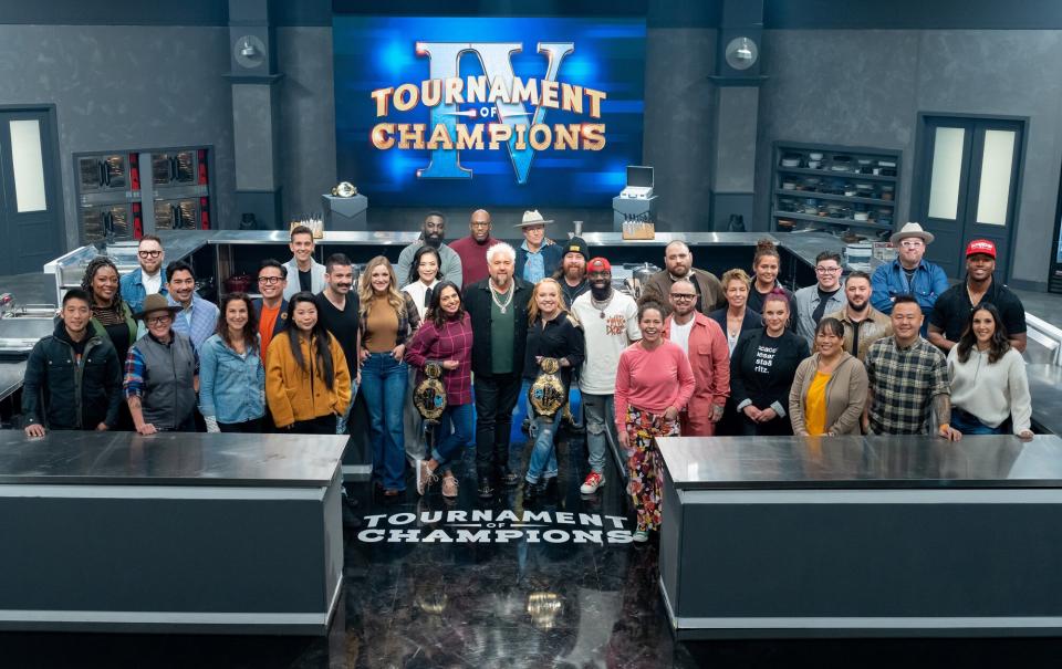 Host Guy Fieri with contestants Shota Nakajima, Tiffany Derry, Ilan Hall, Crista Luedtke, Jose Garces, Tracey Shepos Cenami, Viet Pham, Carlos Anthony, Mei Lin, Joe Sasto, Kelsey Barnard Clark, Maneet Chauhan, Shirley Chung, Eric Adjepong, Madison Cowan, Tiffani Faison, Jonathon Sawyer, Brian Malarkey, Tobias Dorzon, Stephanie Izard, Nate Appleman, Christian Petroni, Elizabeth Falkner, Karen Aukowicz, Antonia Lofaso, Britt Rescigno, Lee Anne Wong, Adam Sobel, Jet Tila, Graham Elliot, Darnell Ferguson, and Leah Cohen, as seen on Tournament of Champions, Season 4.