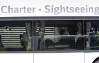 A man wearing a face masks as he sits in a bus after arriving from Craiova in Romania at the 'Schoenefeld Airport' in Berlin, Germany, Thursday, April, 2020. The first planes with harvest workers from Romania have been landing in the morning. (Soeren Stache/dpa via AP)