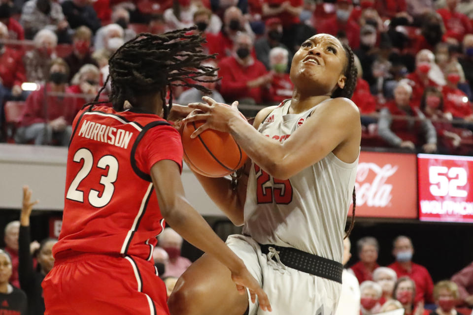 North Carolina State's Kayla Jones (25) drives the ball into Georgia's Que Morrison (23) during the second half of an NCAA college basketball game, Thursday, Dec. 16, 2021, in Raleigh, N.C. (AP Photo/Karl B. DeBlaker)