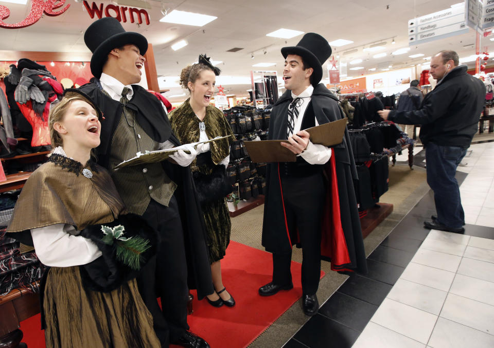 Carollers dressed in traditional costumes perform at Macy's in downtown Boston, Friday, Nov. 23, 2012. Black Friday, the day when retailers traditionally turn a profit for the year, got a jump start this year as many stores opened just as families were finishing up Thanksgiving dinner. (AP Photo/Michael Dwyer)