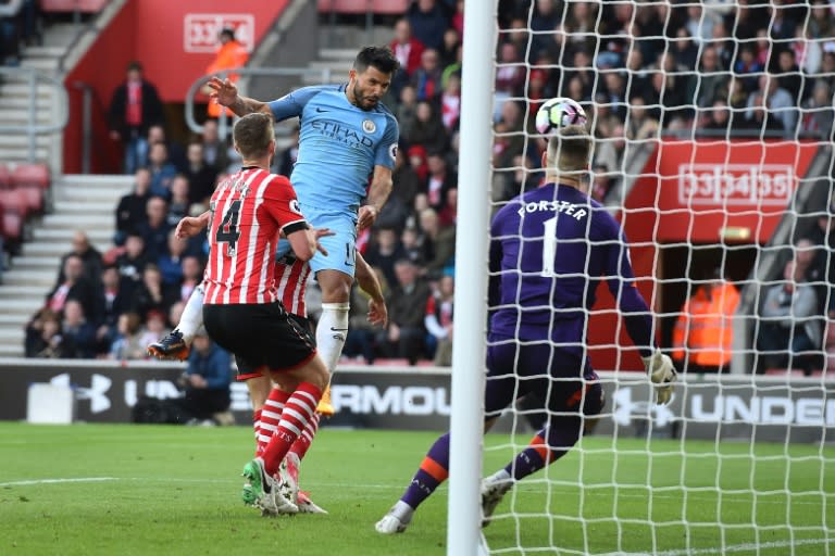 Manchester City's Sergio Aguero jumps to head their third goal past Southampton's goalkeeper Fraser Forster (R) during their match at St Mary's Stadium in Southampton, southern England on April 15, 2017