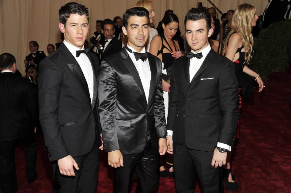 Nick Jonas, left, Joe Jonas, center and Kevin Jonas arrive at the Metropolitan Museum of Art Costume Institute gala benefit, celebrating Elsa Schiaparelli and Miuccia Prada, Monday, May 7, 2012 in New York. (AP Photo/Charles Sykes)