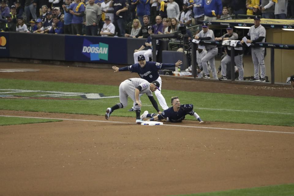 Milwaukee Brewers' Hernan Perez is out after a failed double steal attempt at third base with Colorado Rockies' Nolan Arenado covering during the fourth inning of Game 2 of the National League Divisional Series baseball game Friday, Oct. 5, 2018, in Milwaukee. (AP Photo/Aaron Gash)