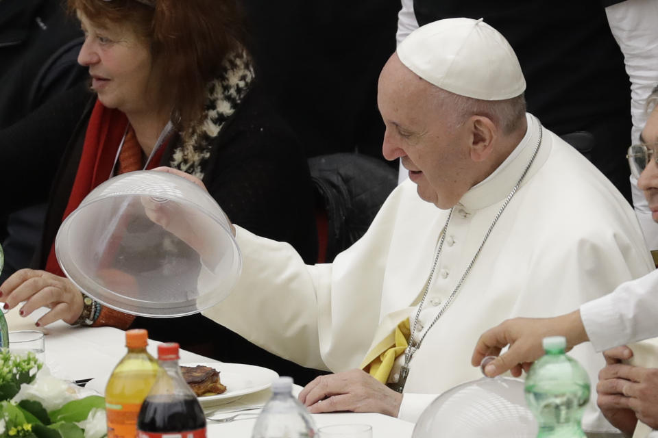 Pope Francis uncovers a dish of lasagna during a lunch, at the Vatican, Sunday, Nov. 18, 2018. Pope Francis is offering several hundred poor people, homeless, migrants, unemployed a lunch on Sunday as he celebrates the World Day of the Poor with a concrete gesture of charity in the spirit of his namesake, St. Francis of Assisi. (AP Photo/Andrew Medichini)