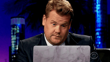 James Corden makes a face as if to say, "not bad," while reading from his laptop on  "The Late Late Show"