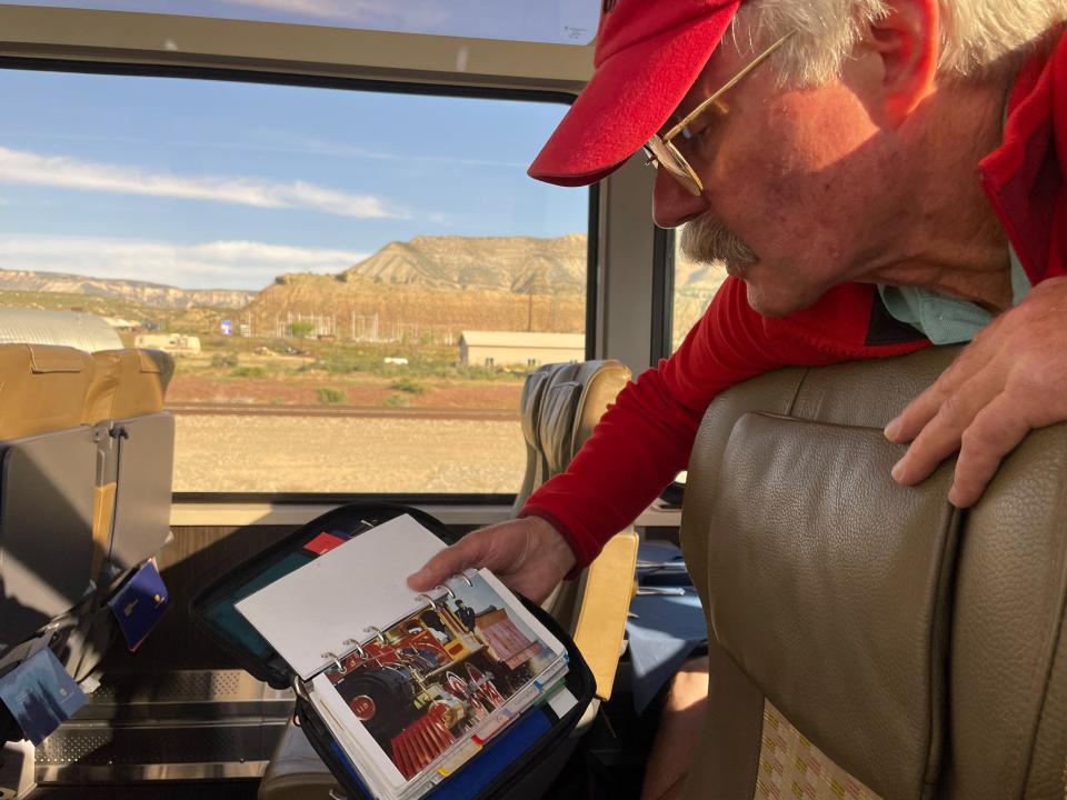 A tour guide on the train shows the author pictures from his time working at national parks.