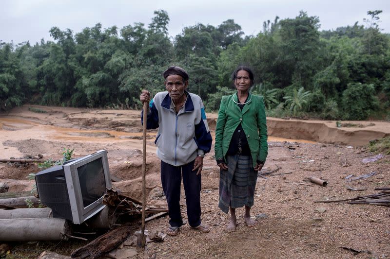 Ho Van Kang stands with his wife Ho Thi Nhe on ruins of their former house which was damaged by a landslide in Quang Tri province