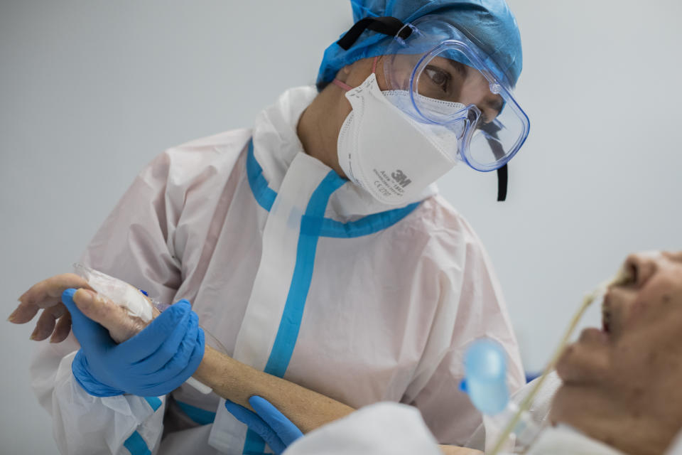 A COVID-19 patient receives a physiotherapy session in the intensive care unit of the Severo Ochoa Hospital in Leganes, on the outskirts of Madrid, Spain, Wednesday, Feb. 17, 2021. (AP Photo/Bernat Armangue)