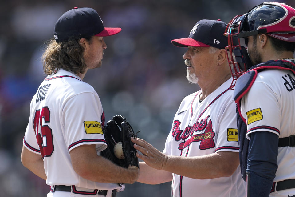 Atlanta Braves pitching coach Rick Kranitz, right, talks with pitcher Dylan Dodd, left, as catcher Travis d'Arnaud looks on in the first inning of a baseball game against the Washington Nationals, Sunday, Oct. 1, 2023, in Atlanta. (AP Photo/John Bazemore)
