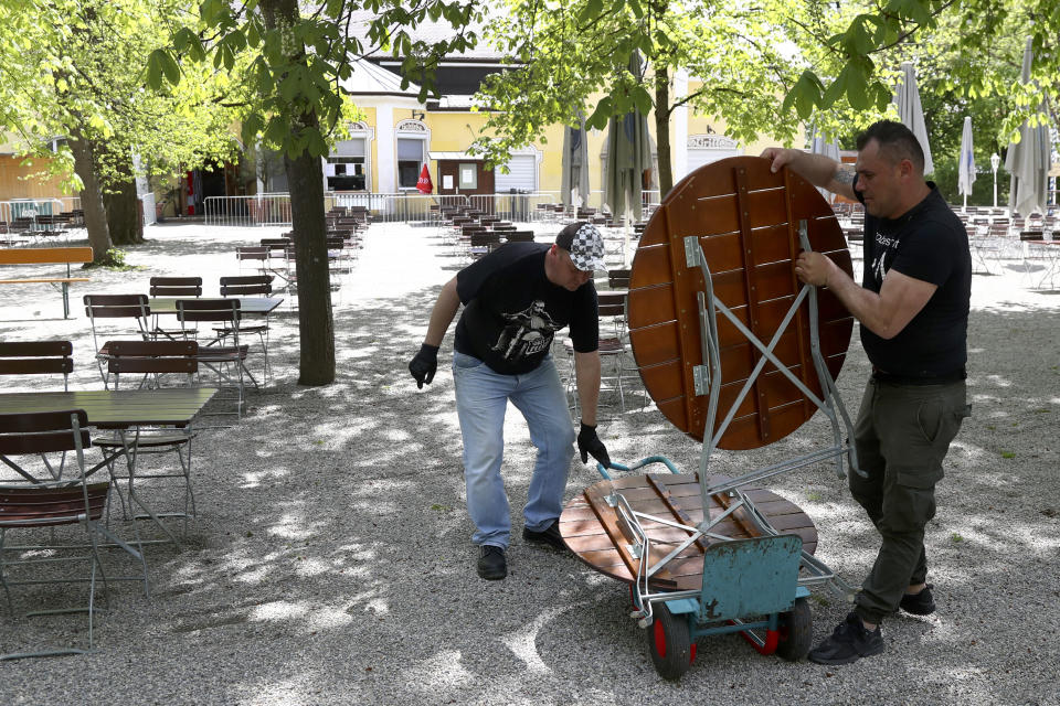 Employees of the 'Taxisgarten' beer garden prepare benches and tables for the re-opening in Munich, Germany, Monday, May 10, 2021. (AP Photo/Matthias Schrader)