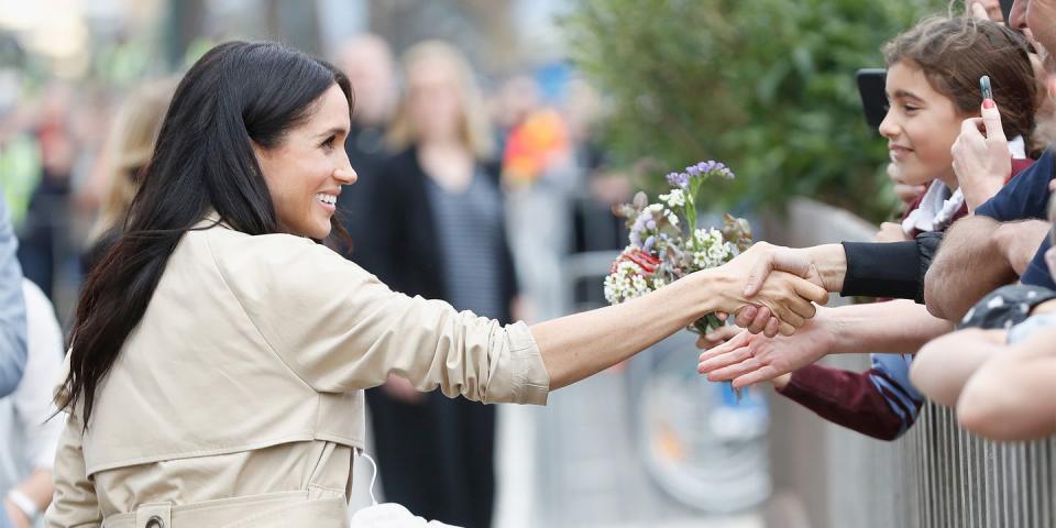 <p>Meghan shakes a fan's hand.</p>