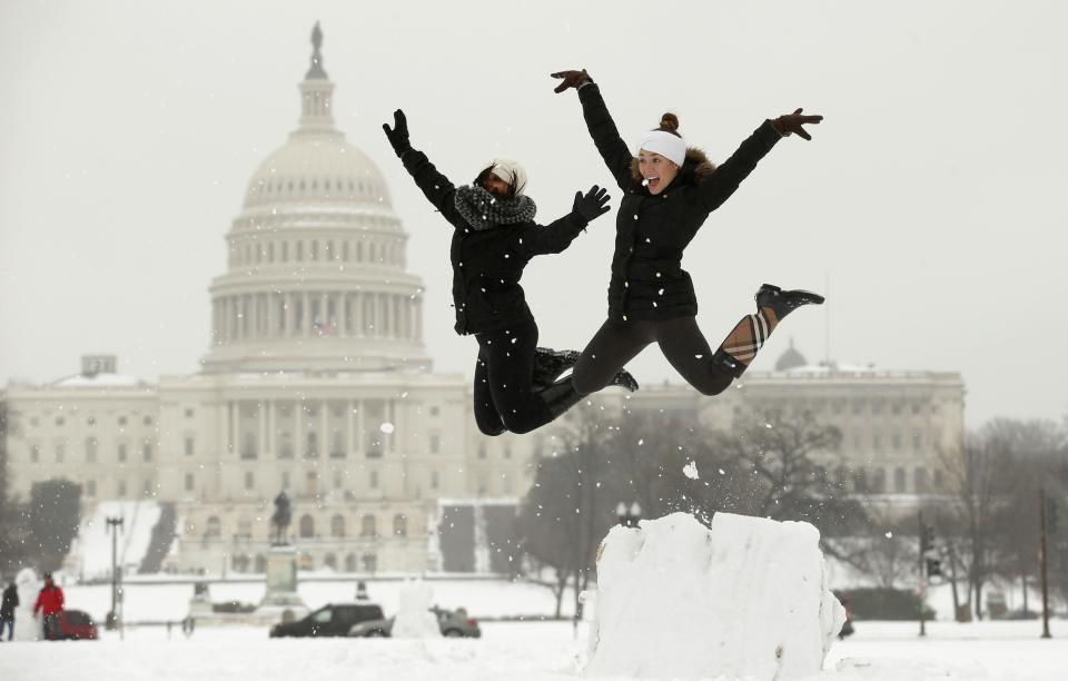 Sipe and Gilliam of Washington D.C. leap off a snow podium they made near the U.S. Capitol in Washington