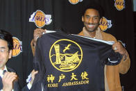In this Dec. 14, 2001, photo, Kobe Bryant, then NBA player from the Los Angeles Lakers, poses with a jersey after being named the newest ambassador for the city of Kobe, Japan before a game against the Los Angeles Clippers at the Staples Center, in Los Angeles, Calif. Bryant died in a helicopter crash Sunday, Jan. 26, 2020. Tetsunori Tanimoto, an official at the Kobe Beef Marketing & Distribution Promotion Association, in Kobe, central Japan, expressed his deep condolences for Kobe Bryant’s death. “He helped make Kobe Beef known throughout the world,” Tanimoto said in a telephone interview with The Associated Press Monday. (Kyodo News via AP)