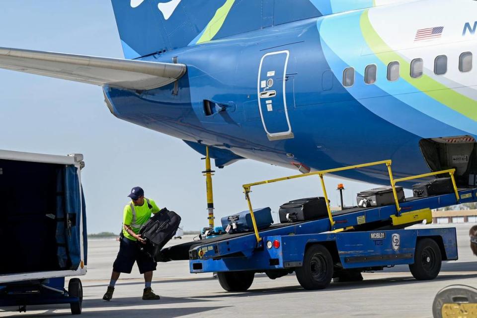 A ramp agent unloads baggage from a plane arriving at Kansas City International Airport.