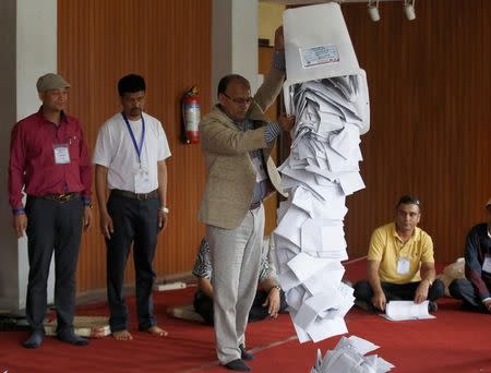 An official from the election commission pours the ballot papers from the box, as officials start counting the votes, a day after the local election of municipalities and villages representatives in Kathmandu, Nepal May 15, 2017. REUTERS/Navesh Chitrakar