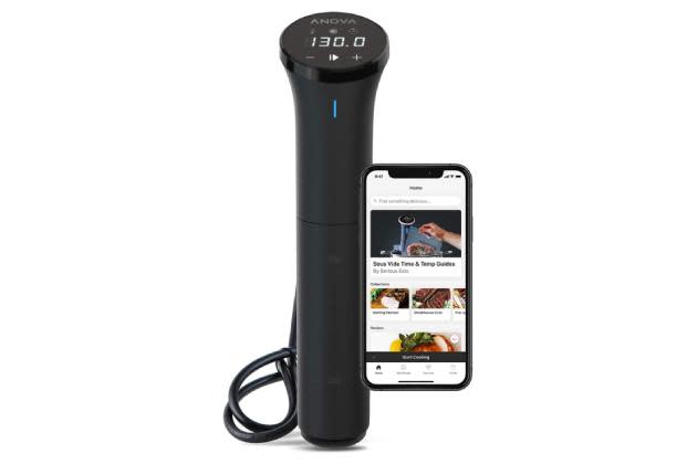 Un sous vide negro con un teléfono inteligente que muestra la aplicación Anova