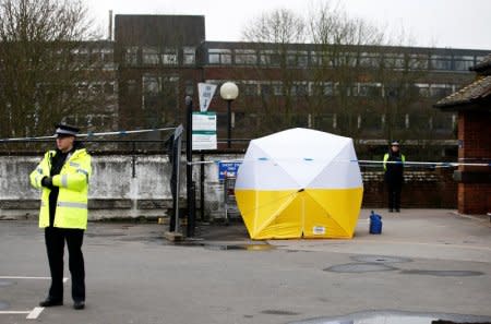 FILE PHOTO: Police officers stand behind a cordon placed around a payment machine covered by a tent in a supermarket car park near to where former Russian intelligence agent Sergei Skripal and his daughter Yulia were found poisoned in Salisbury, Britain, March 13, 2018. REUTERS/Henry Nicholls