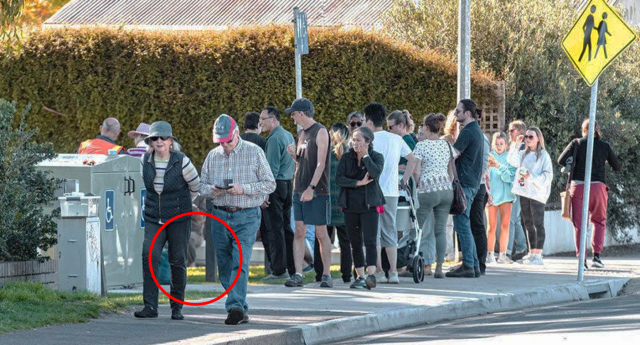 A red circle around a small part of the image, likely where the seal is. A crowd of people taking a photo of the seal.