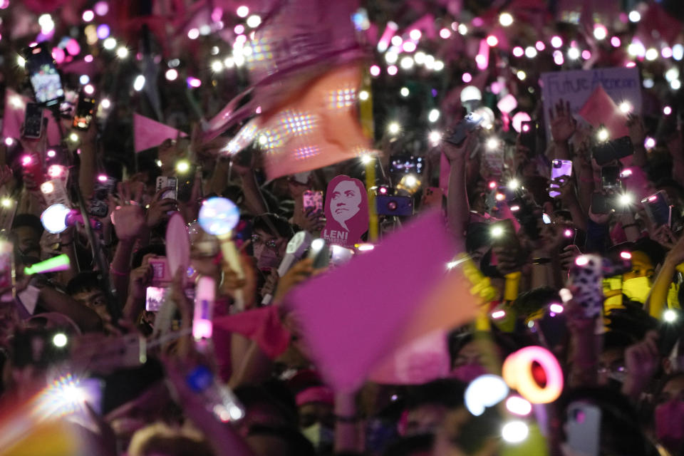 A picture of Philippine Vice President Leni Robredo is seen as supporters wave their mobile phones and flags during her presidential campaign rally in Pasay City, Philippines on April 23, 2022. The winner of May 9, Monday's vote will inherit a sagging economy, poverty and deep divisions, as well as calls to prosecute outgoing leader Rodrigo Duterte for thousands of deaths as part of a crackdown on illegal drugs. (AP Photo/Aaron Favila)