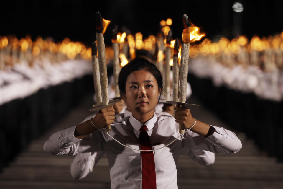 North Korean youths holding torches march during a torch light march at the Kim Il Sung Square in conjunction with the 70th anniversary of North Korea's founding day in Pyongyang, North Korea, Monday, Sept. 10, 2018. Tens of thousands of North Koreans rallied in the square in the final major event of the country's 70th anniversary, an elaborate celebration that was focused on Korean unity and economic development and that deliberately downplayed the missiles and nuclear weapons that brought the North to the brink of conflict with the United States just one year ago. (AP Photo/Kin Cheung)