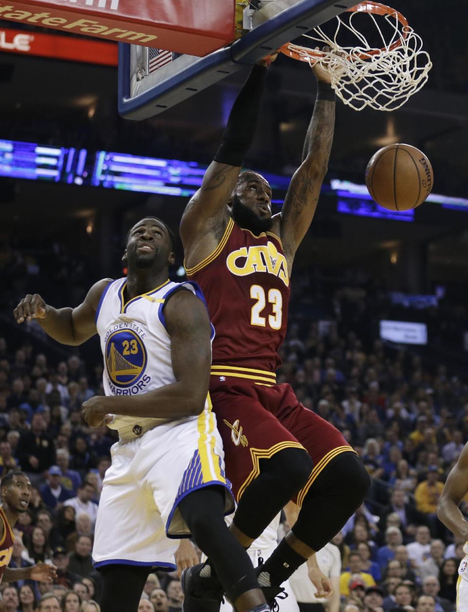 Cleveland Cavaliers' LeBron James, right, scores over Golden State Warriors' Draymond Green during the first half of an NBA basketball game, Monday, Jan. 16, 2017, in Oakland, Calif. (AP Photo/Ben Margot)