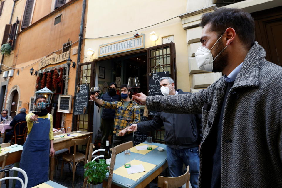 Staff members and customers make a toast at a restaurant in Trastevere after the coronavirus disease (COVID-19) restrictions were eased in Lazio region, Rome, Italy, February 1, 2021. REUTERS/Guglielmo Mangiapane