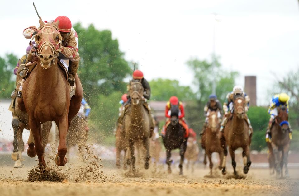 Rich Strike, left, with jockey Sonny Leon aboard, wins the Kentucky Derby.