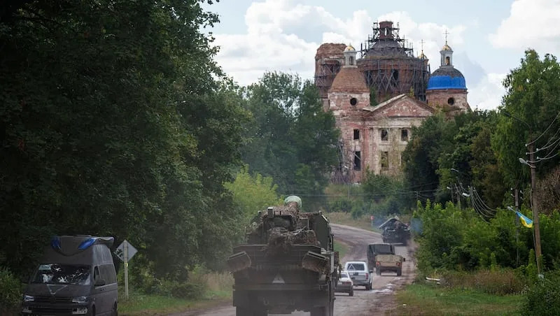 Military vehicles drive near the Russian-Ukrainian border in Sumy region, Ukraine, Tuesday, Aug. 13, 2024.